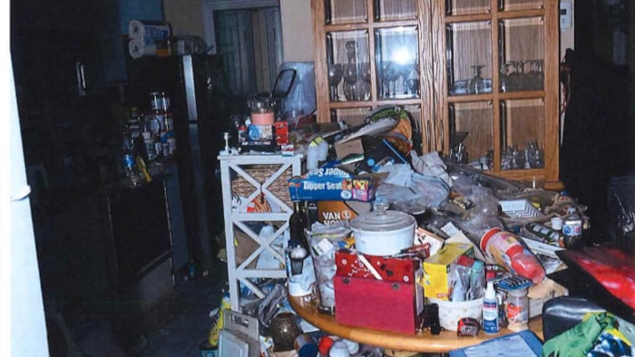 Une photo d'une salle à manger encombrée d'objets et de détritus.