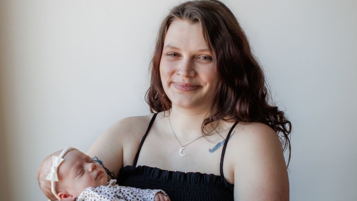 Une femme tient un bébé dans ses bras.