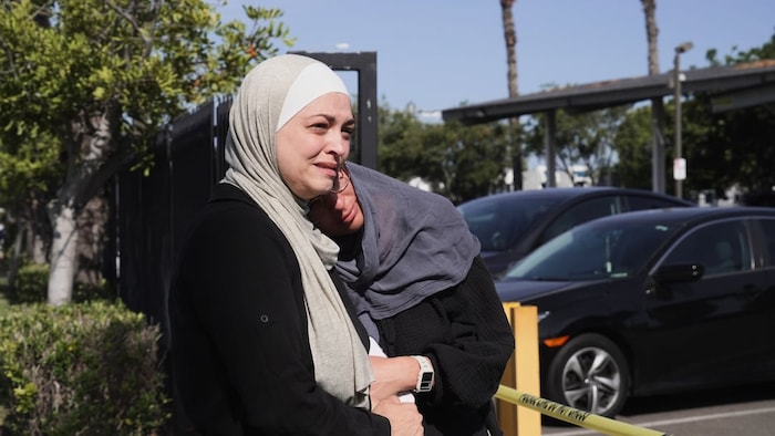 Deux femmes bouleversées s'enlacent.
