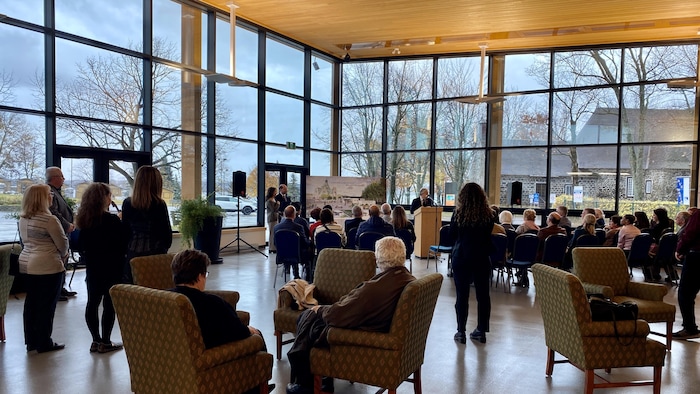 L'intérieur du pavillon du sanctuaire, vitré et lumineux, où sont rassemblés plusieurs personnes à l'occasion de l'inauguration 