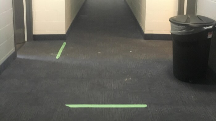 Un corridor dans un motel avec bandes vertes au sol