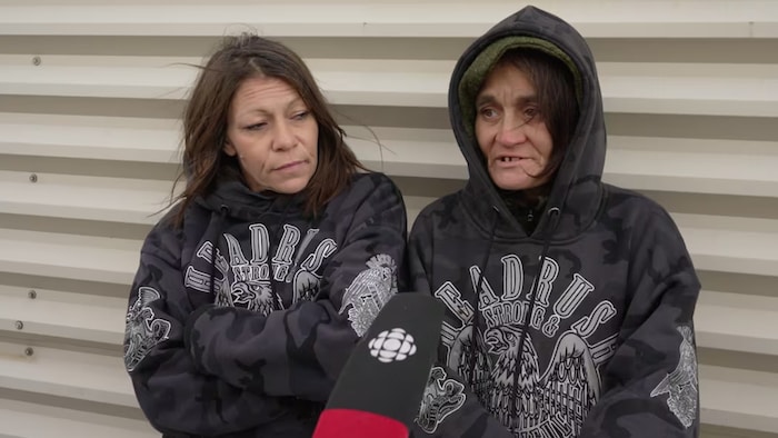 Deux femmes qui portent des chandails arborant un aigle parlent à une journaliste de CBC/Radio-Canada.