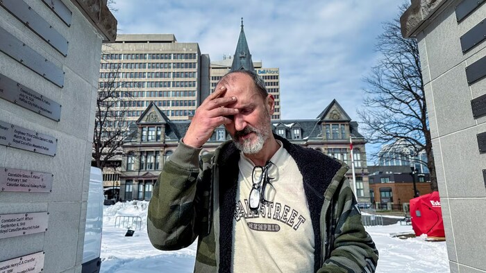 Un homme se prend la tête en plein hiver, dans un campement de fortune d'Halifax. 