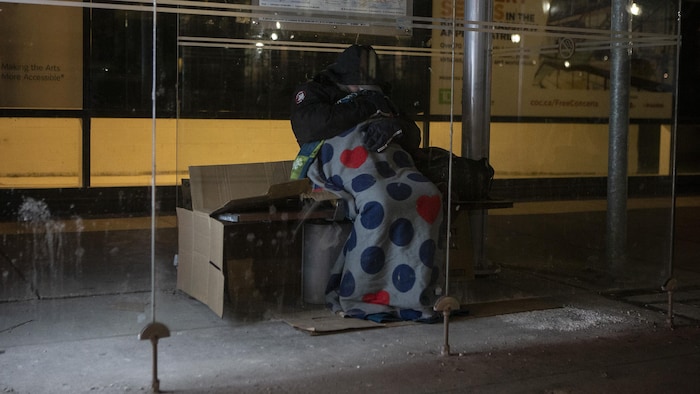 Un homme dort dans un abribus à Toronto.