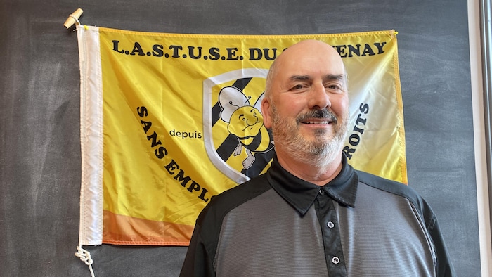 Sylvain Bergeron pose devant un drapeau.
