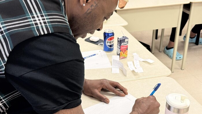 Sans Pression écrit sur un feuille lors d'un atelier d'écriture à l'école de Pikogan.