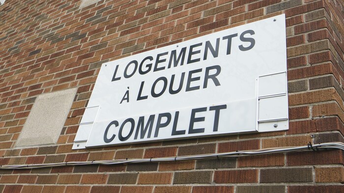 Une pancarte qui dit «Logements à louer. Complet» sur un immeuble.