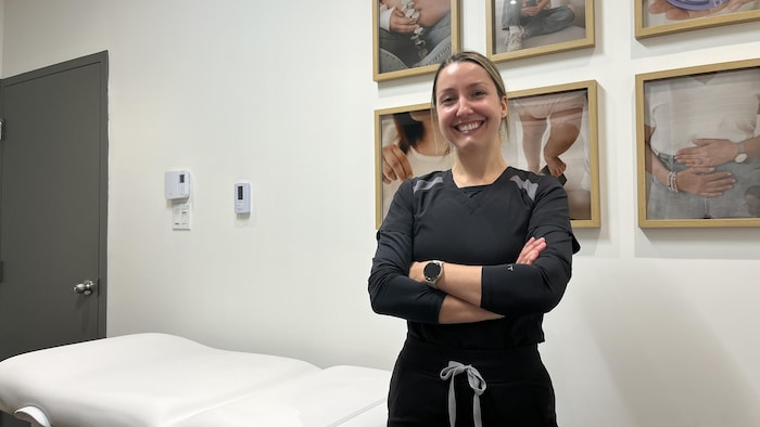 une infirmière en uniforme sourit à la caméra