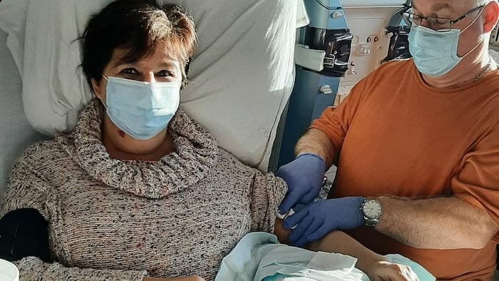 Une femme en traitement d'hémodialyse assistée par un homme.
