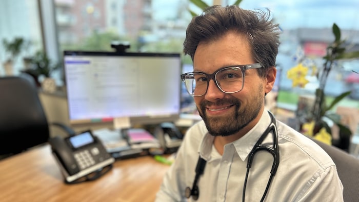 Un médecin assis à son bureau.