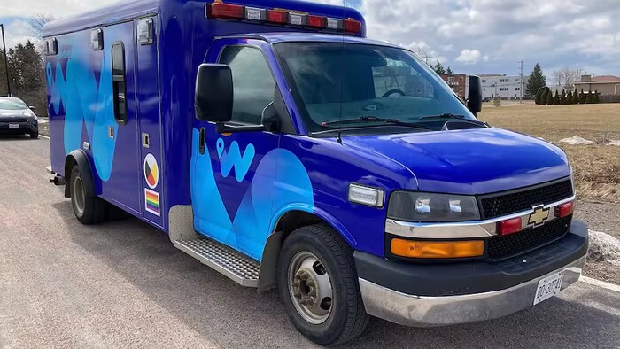 Une ambulance stationne au bord d'une route.