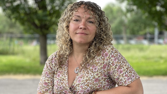Carolane Campeau assise à une table à picnic dans un parc.