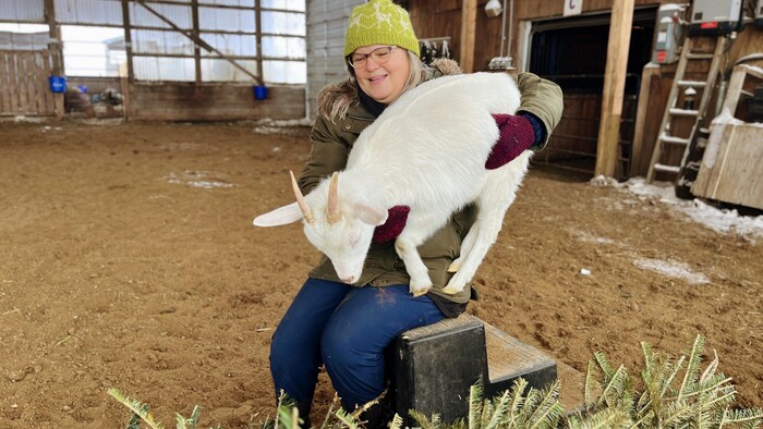 Louise May, assise avec une chèvre.