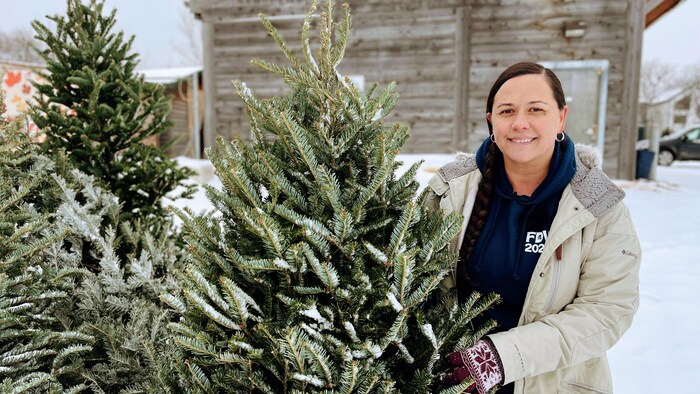 Chantal Vielfaure tenant un sapin donné.