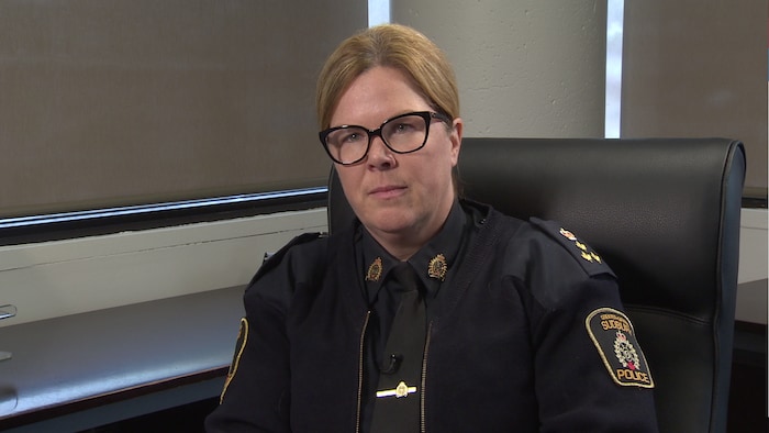 Une femme assise dans son bureau portant une tenue de police.