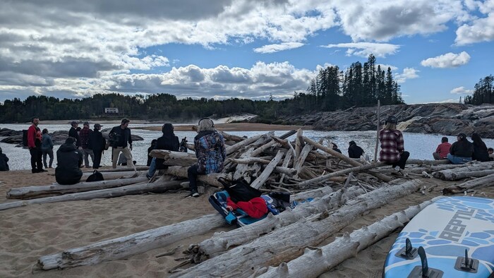 Des personnes sont assises devant une rivière.