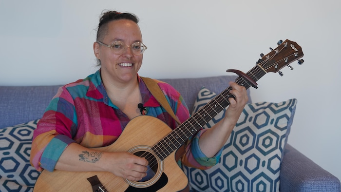Sara Rose Hébert, sur un sofa avec sa guitare
