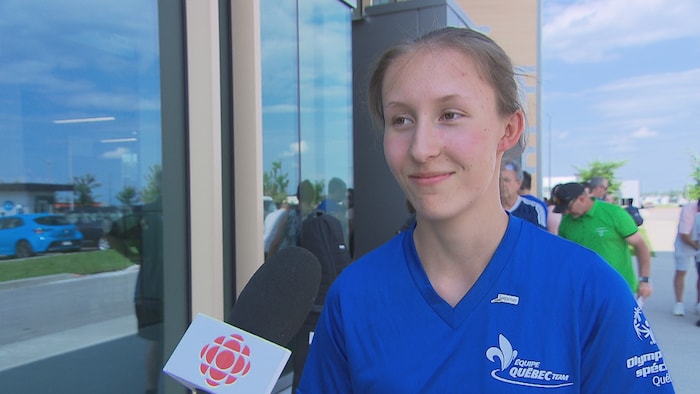 Une jeune femme devant un micro de Radio-Canada.
