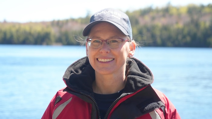Portrait de la biologiste Sarah Granier devant le lac des Baies dans la réserve faunique Duchénier.