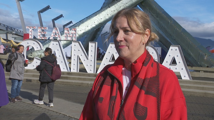Sarah Kirby-Yung est devant une enseigne de l'Équipe Canada