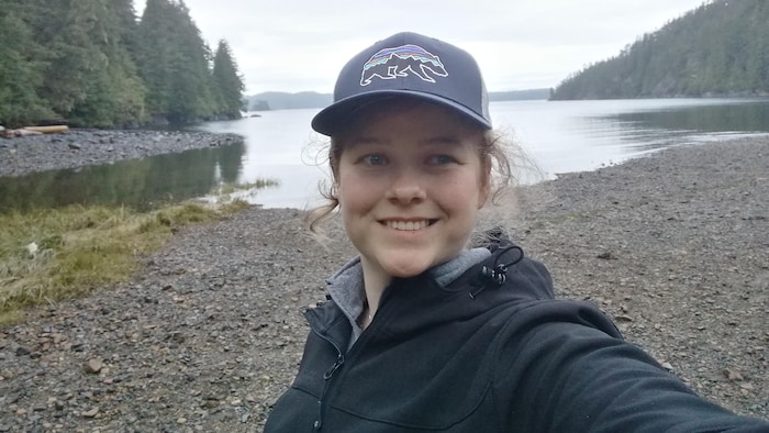Sarah Shelley prend un égoportrait devant un paysage.
