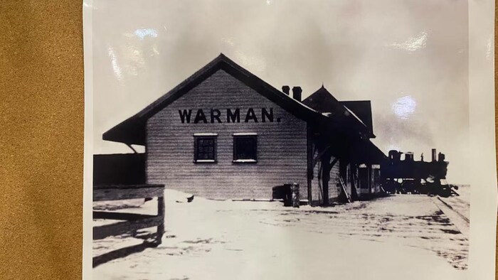 Une photo d'une affiche des photos historiques de bâtiments portant le nom Warman.