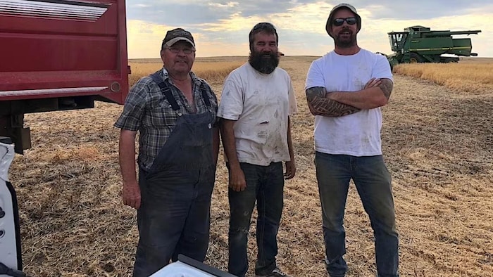 Troy Weppler, à l'extrême droite, à sa ferme près de Morse, en Saskatchewan, debout aux côtés d'Earl Weppler et de Paul Grajcyk.