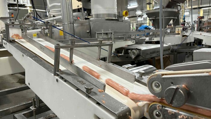 Une machine fabrique des saucisses.