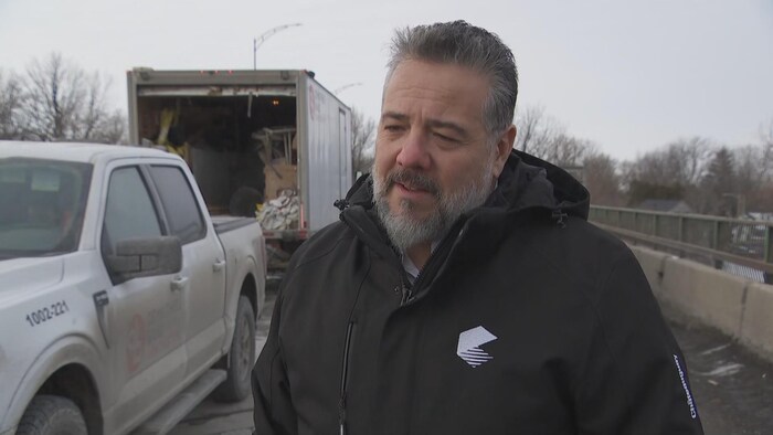 Le maire de Châteauguay, Éric Allard, répond aux questions d'une journaliste. 