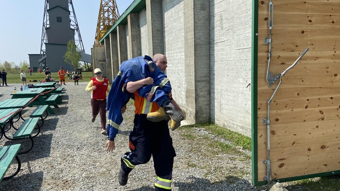 Un membre de l'équipe de sauvetage minier de la mine Eldorado transporte une victime sur son épaule lors de la compétition amicale, samedi.
