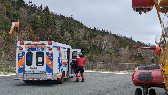 Une ambulance à côté d'un hélicoptère de recherche et sauvetage.