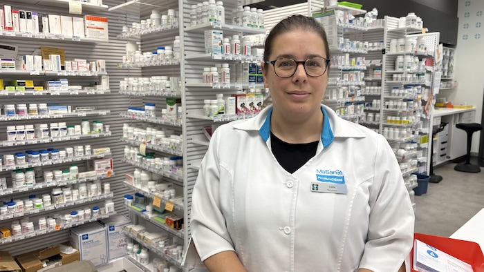 Une pharmacienne devant le laboratoire d'une pharmacie.