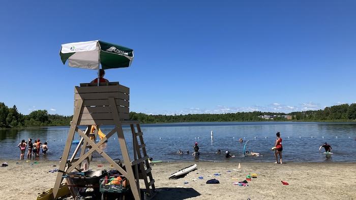 Un sauveteur surveillant des jeunes baigneurs dans un lac.