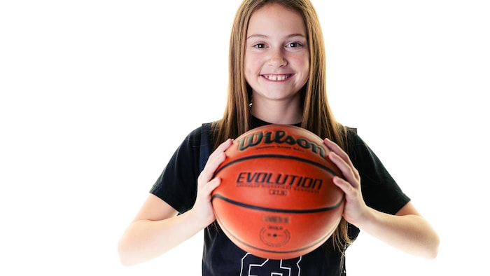 Scarlett Frost tient un ballon de basketball.