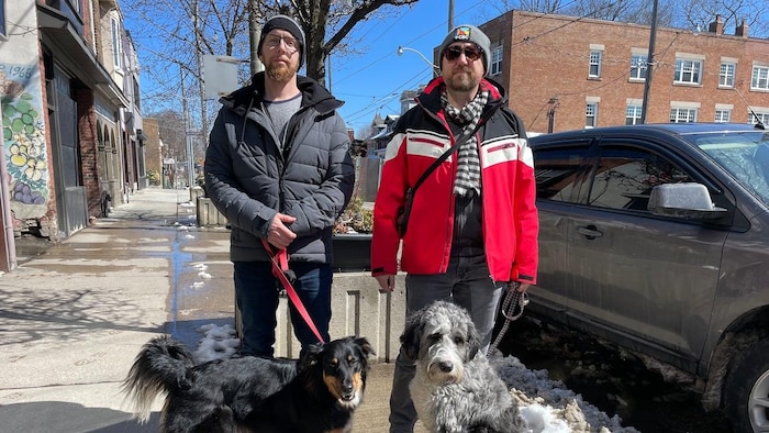 Tyler Schlomb et Mark Rullo sont pris en photos sur la rue avec leur chien.