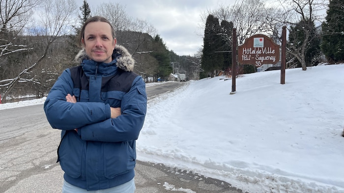 Philôme La France se tient devant l'affiche de l'hôtel de ville en hiver.