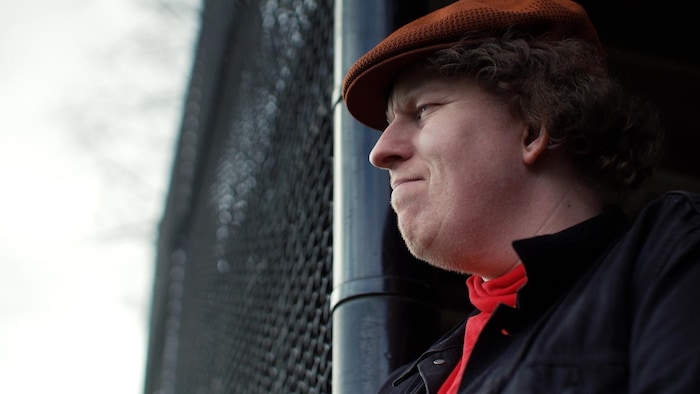 Scott Betson avec une casquette sur la tête, déguisé en Bernard.