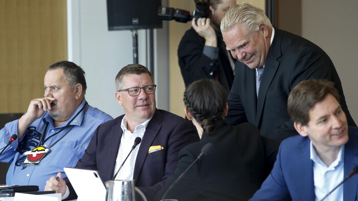 Le premier ministre de la Saskatchewan, Scott Moe, discute avec la présidente du Ralliement national des Métis, Cassidy Caron, et avec le premier ministre de l'Ontario, Doug Ford, lors de la rencontre des premiers ministres à Winnipeg, le 10 juillet 2023.