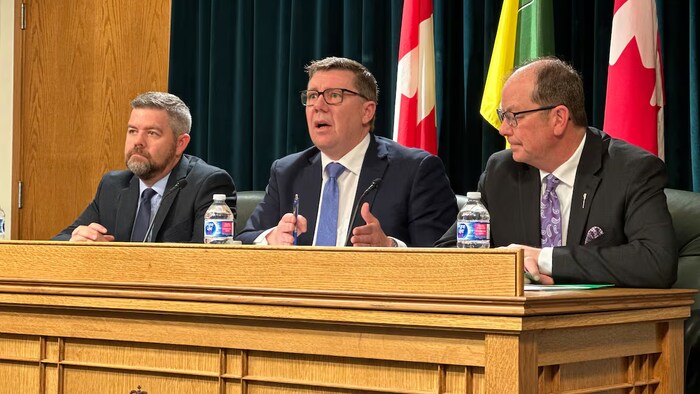 Scott Moe, Jeremy Harrison et Travis Keisig en conférence de presse.
