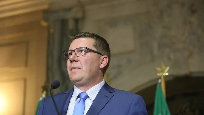 Scott Moe devant un micro.