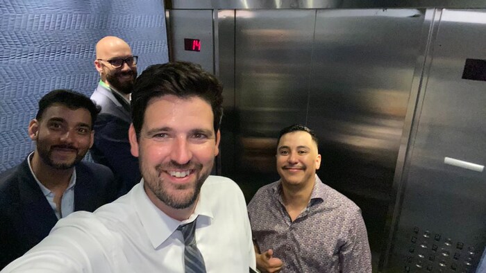 Cuatro hombres en un ascensor.