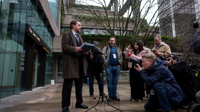 Sean Orr, conseiller municipal à Vancouver, était devant les palais de justice de Vancouver, le mardi 10 mars. Des journalistes et des photographes sont devant lui.