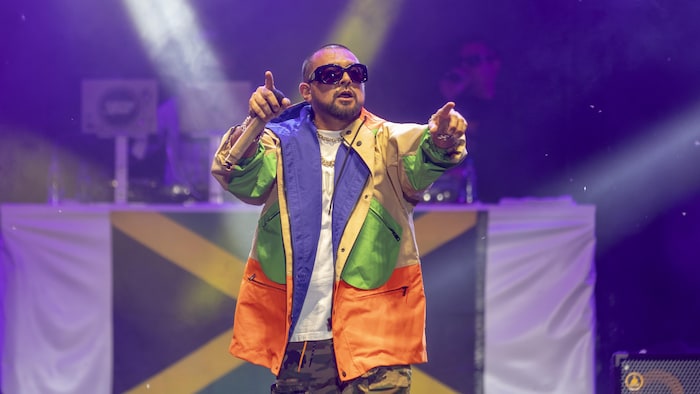 Sean Paul pointe les doigts de ses deux mains en absorption des spectateurs.