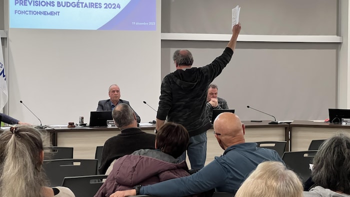 Un homme lève la main lors d'un conseil municipal à Gatineau.