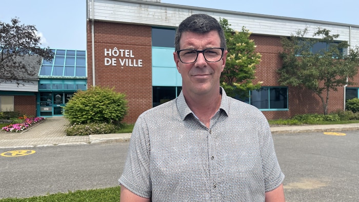 Le maire pose devant l'hôtel de ville.