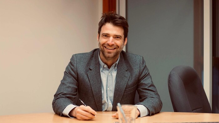 Sébastien L'Écuyer est assis à un bureau.