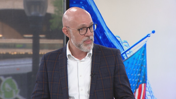 Un homme discute sur un plateau de télé.