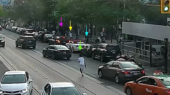 Abdulkadir Handule qui court avec une arme à feu au milieu d’une rue.