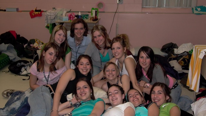 Un groupe de filles rassemblées sur le sol d'une salle de classe.