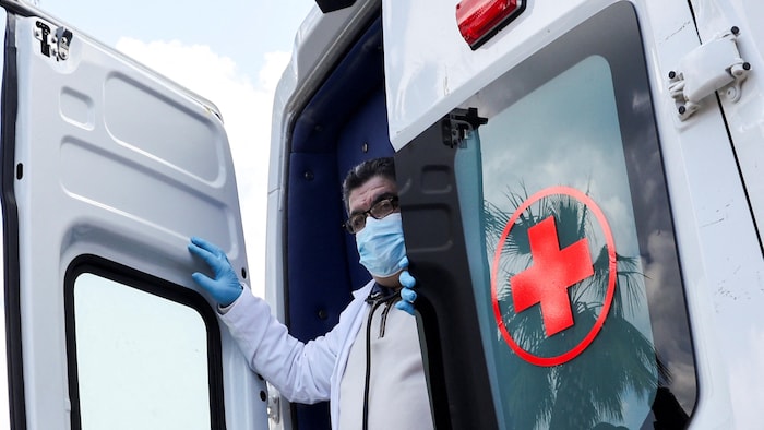A Red Cross volunteer coming out of a vehicle at a mobile clinic for war-displaced people in Lebanon.